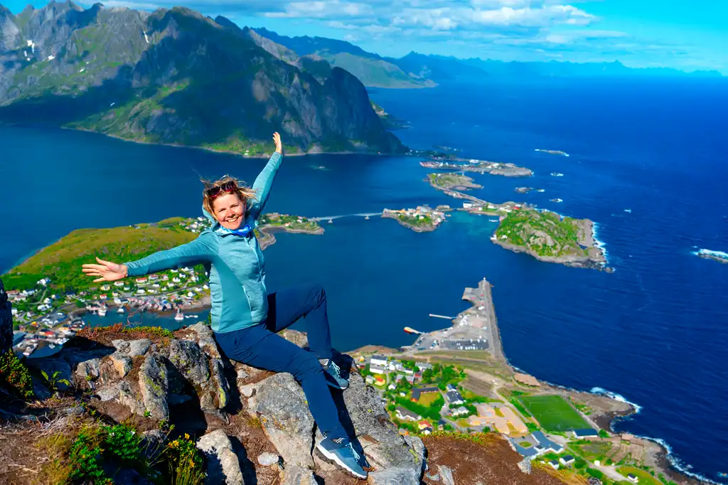 excursionista disfruta de la vista sobre el borde del acantilado de las islas lofoten, en Noruega, Reinebringen