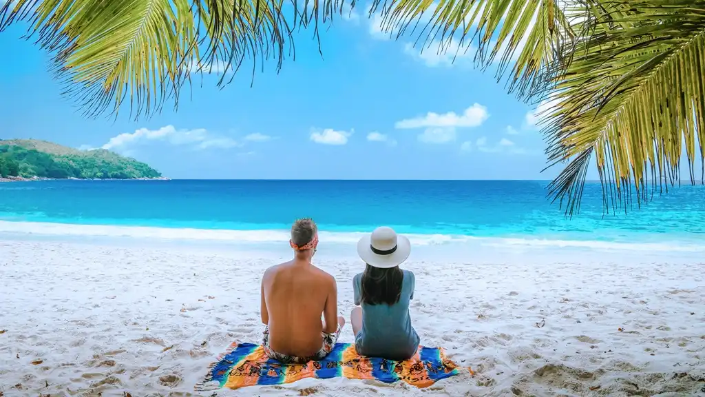 feliz pareja joven hombre y mujer en la playa blanca tropical en la isla de Praslin, Seychelles