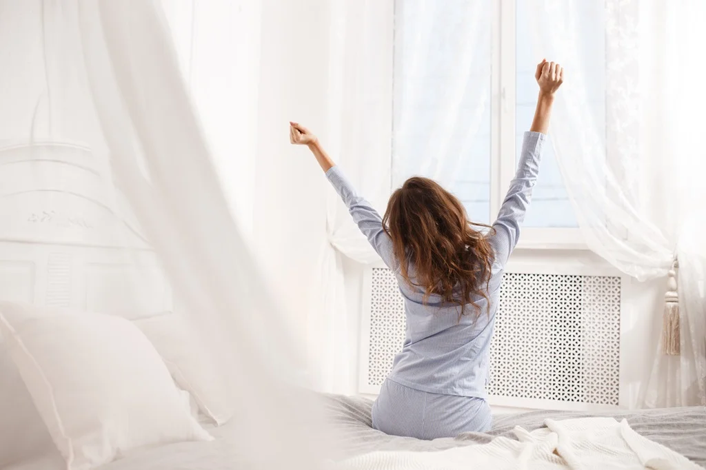 Mujer se estira después de una noche de sueño reparador