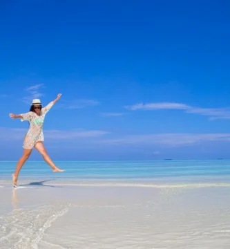Mujer joven disfrutando de sus vacaciones en una playa tropical en Maldivas