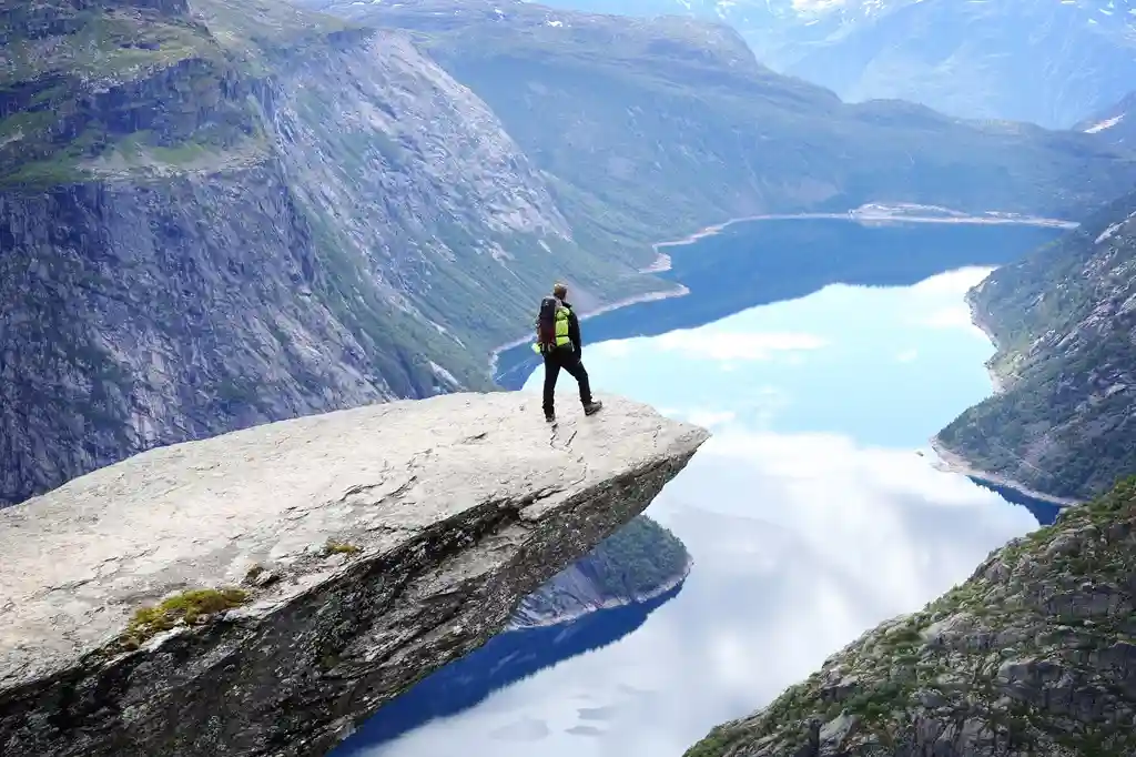 Hombre parado en el borde del acantilado de Trolltunga en Noruega